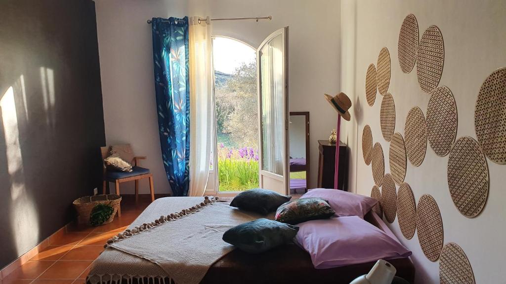 a bedroom with a bed with pillows and a window at BIENVENUE in Le Revest-le-Eaux