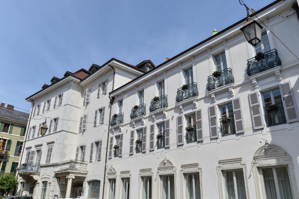 a large white building with potted plants on it at ROYAL Annecy Apparthôtel in Annecy