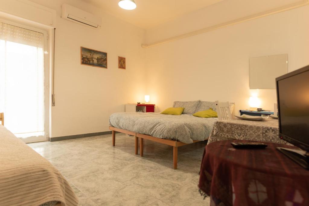 バーリにあるArchita Guest Houseのベッドとテレビのあるリビングルーム