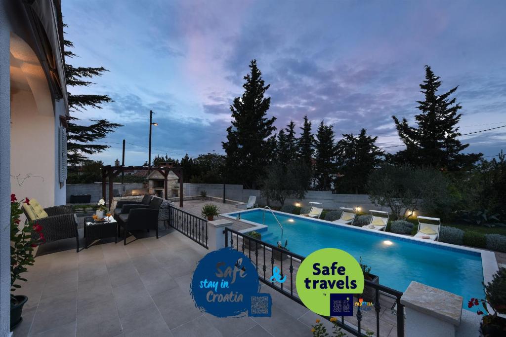 a swimming pool with a sign that reads safe travels at Villa Meštrović in Zadar