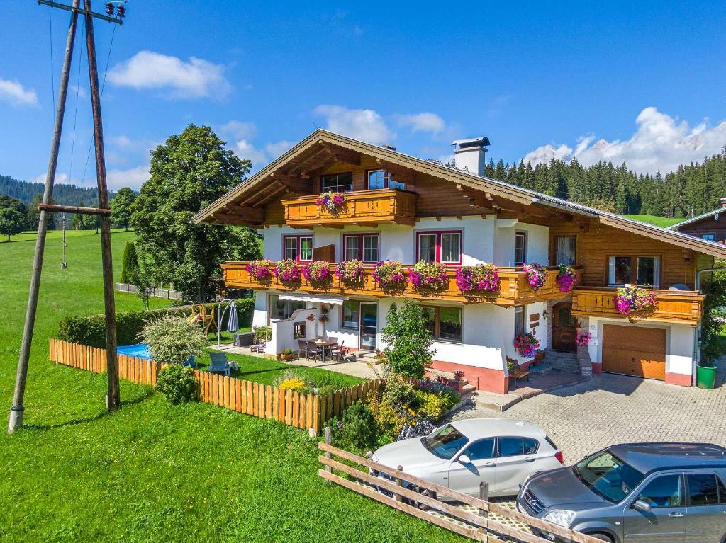 una casa con coches aparcados delante de ella en Haus Ferienglück, en Ramsau am Dachstein