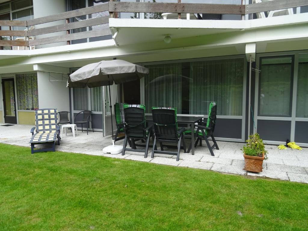 a patio with a table and chairs and an umbrella at Duinweg 35 in Westkapelle