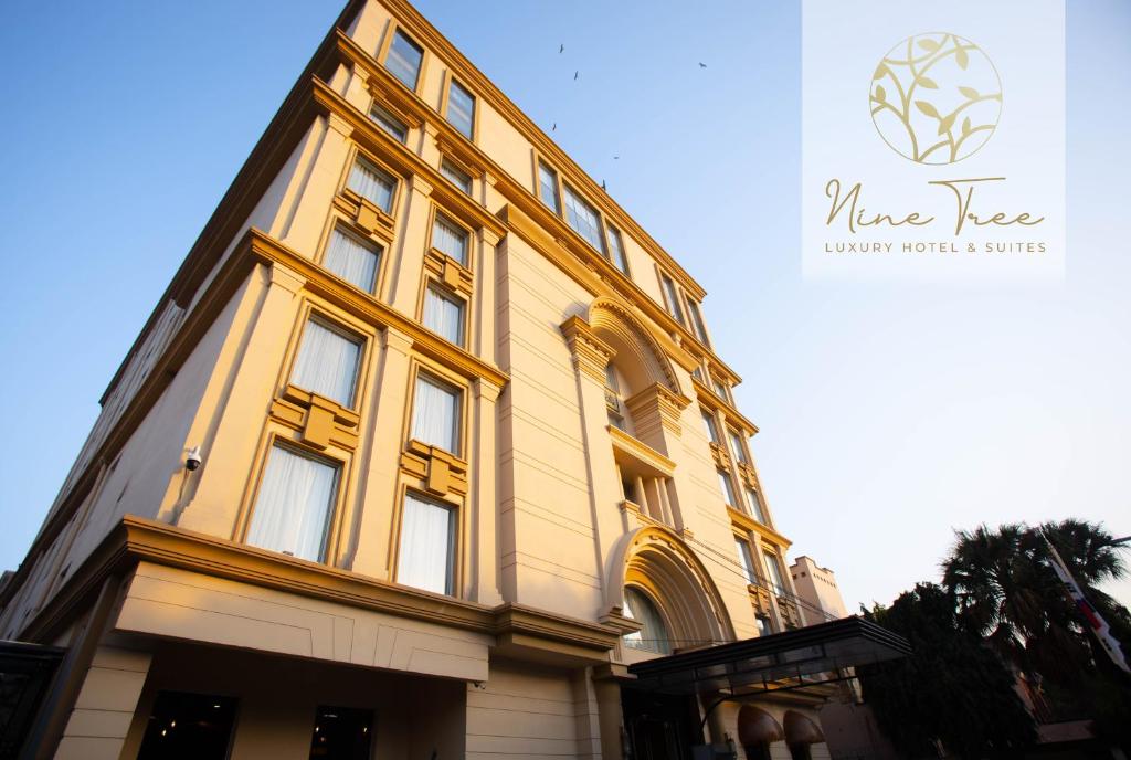 ein gelbes Gebäude mit Seitenfenstern in der Unterkunft Nine Tree Luxury Hotel & Suites Lahore in Lahore