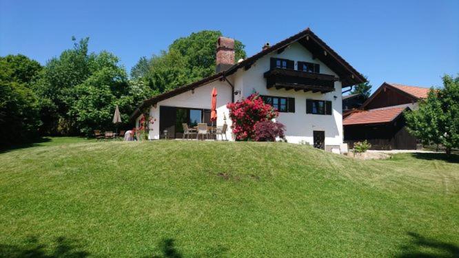 una casa in cima a una collina erbosa di Ferienhaus am Chiemsee a Breitbrunn am Chiemsee