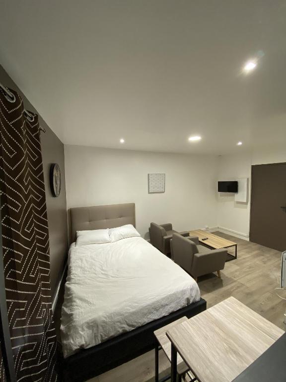 a bedroom with a bed and a couch and a table at Lh Rooms Location in Le Havre