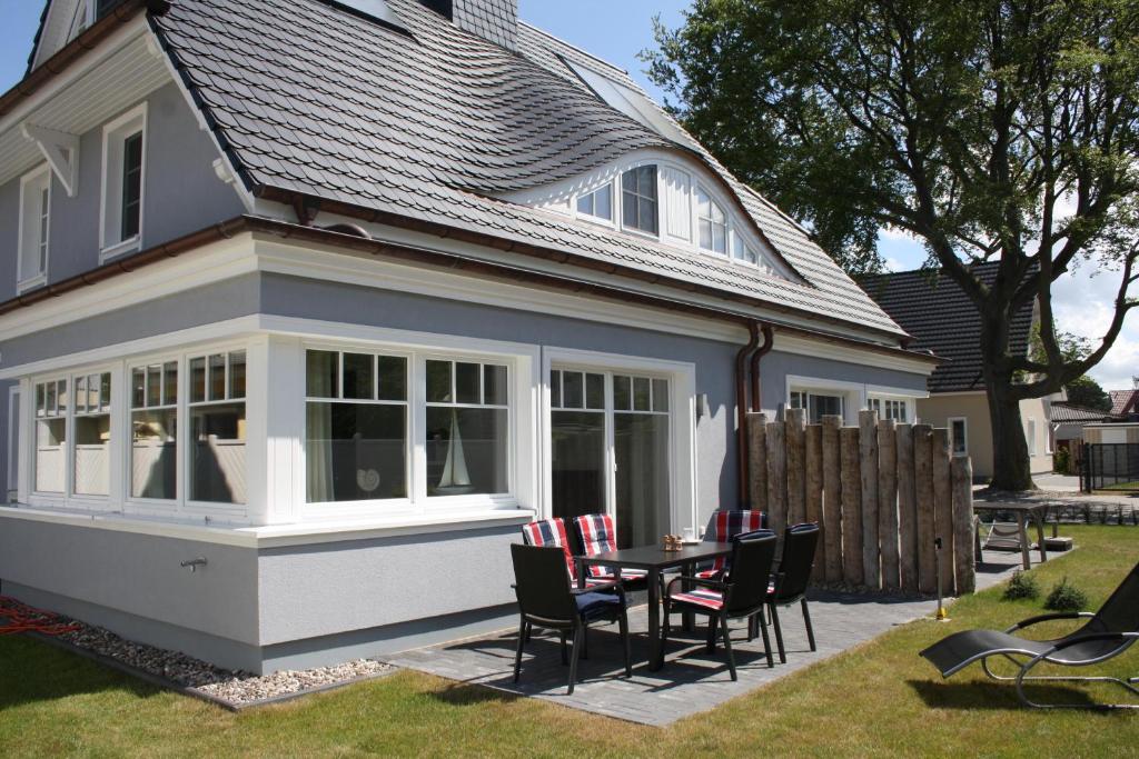 a house with a patio with a table and chairs at Haus Bugspriet Haegerende in Zingst