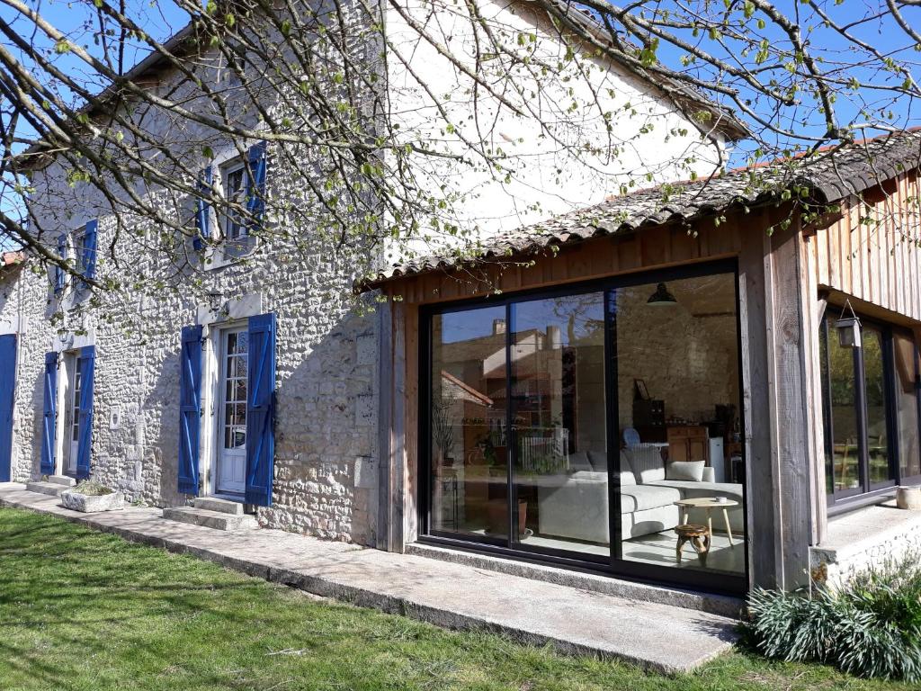 ein Haus mit einer großen Glasschiebetür in der Unterkunft La Maison des Escargots in Blanzay