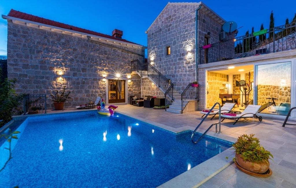 a swimming pool in front of a brick building at Villa Marija in Gromača