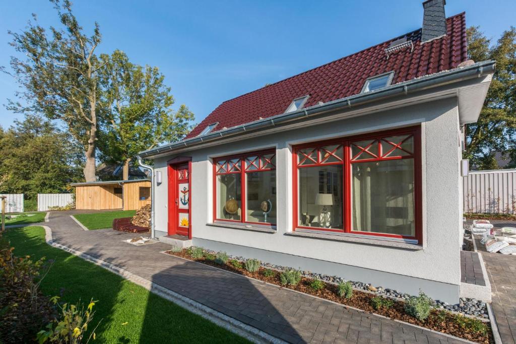 a house with red windows and a yard at Buten un Binnen in Zingst
