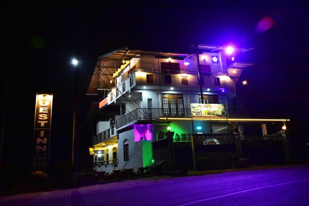 a building with purple and green lights on it at night at Lucky Star View Inn in Bandarawela