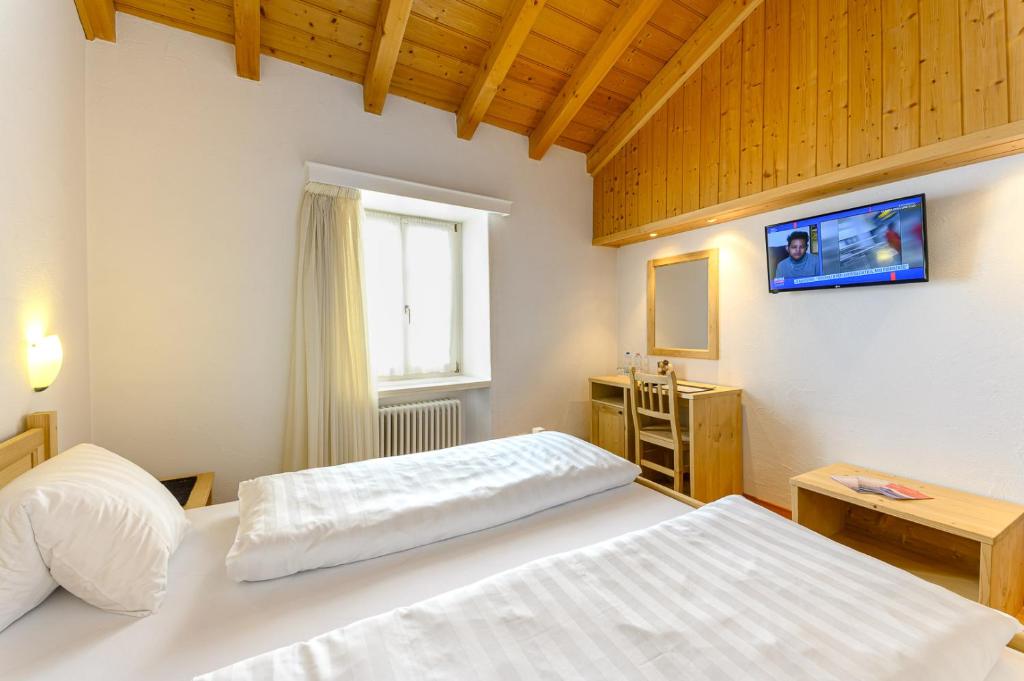 Postel nebo postele na pokoji v ubytování Hotel Centrale, Typically Swiss
