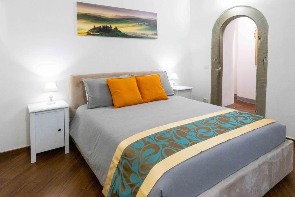 1 dormitorio con 1 cama grande con almohadas de color naranja en Maison Orange Florence, en Florencia