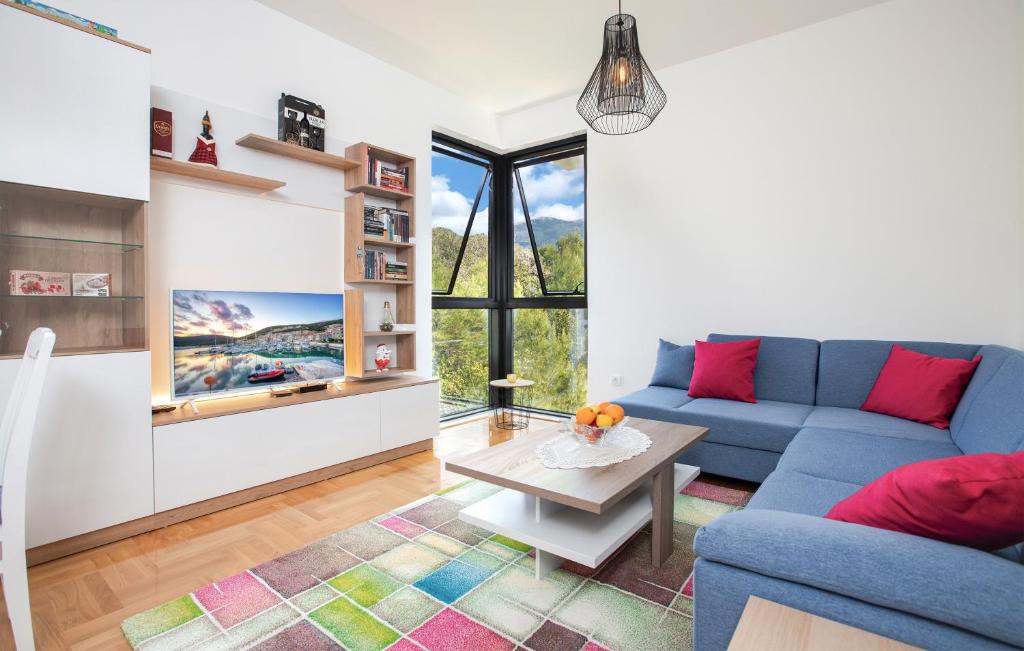 a living room with a blue couch and a table at Piskalina Apartment in Tivat