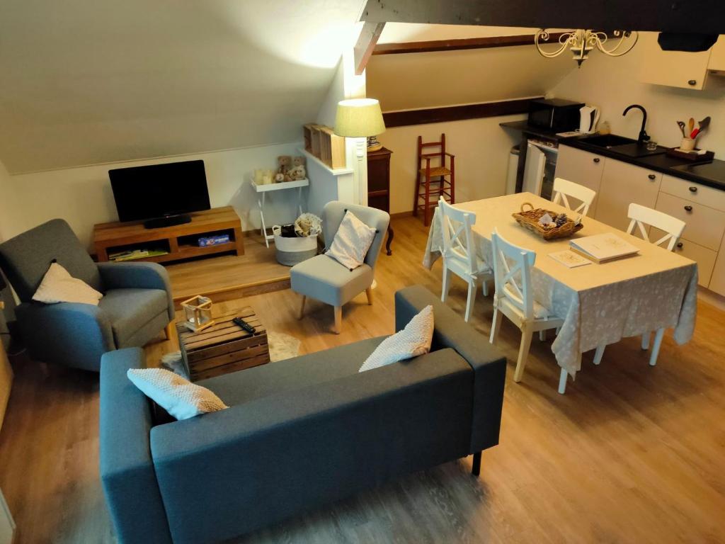 uma sala de estar com um sofá azul e uma mesa em Gastenverblijf Hof Moye Tyt em Middelkerke