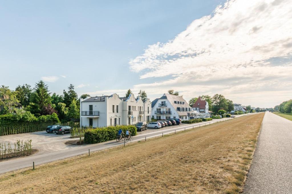 a street in a town with houses and cars at Sonne und Meer in Zingst