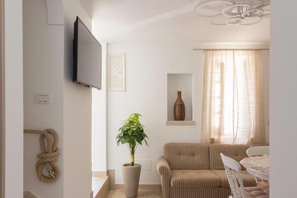 salon z kanapą i telewizorem na ścianie w obiekcie Stella Bianca w mieście Savelletri di Fasano