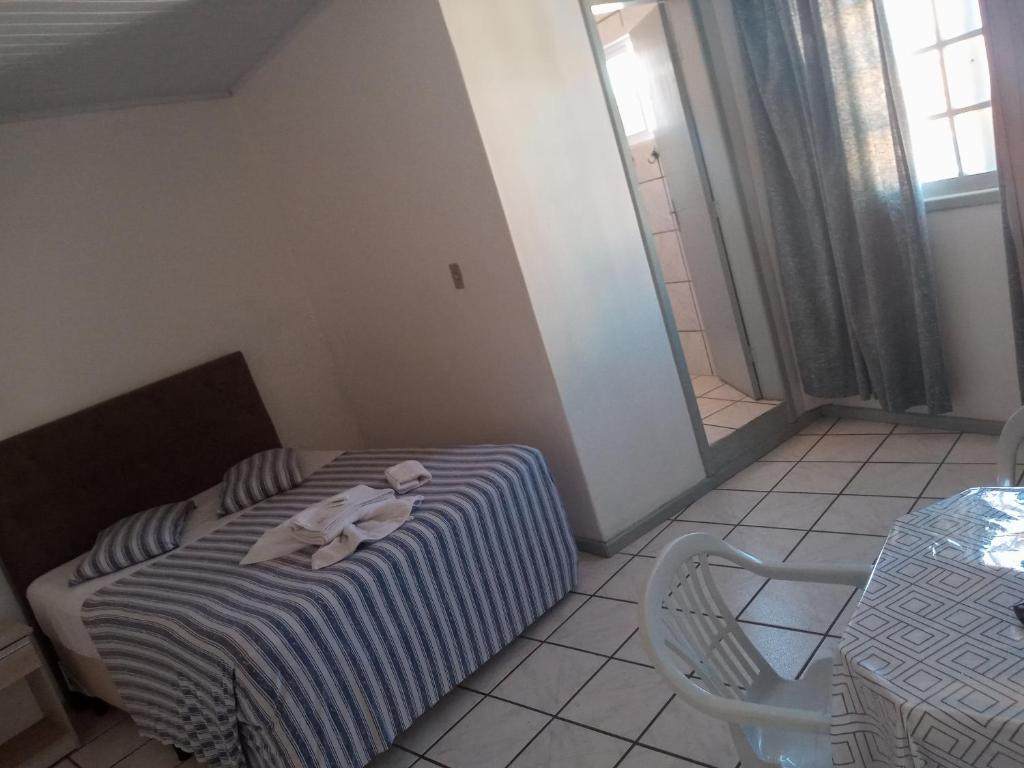 Hotel e Restaurante Recanto da Lagoa في لاغونا: غرفة نوم عليها سرير وفوط