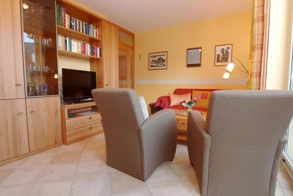 a living room with two chairs and a television at Lindenstrassee Haus Sonnengru_ in Zingst