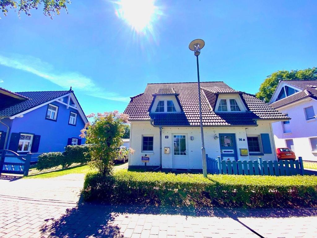 une maison avec des maisons bleues et blanches dans une rue dans l'établissement Alte Reihe 14 _Haus Teja_, à Zingst