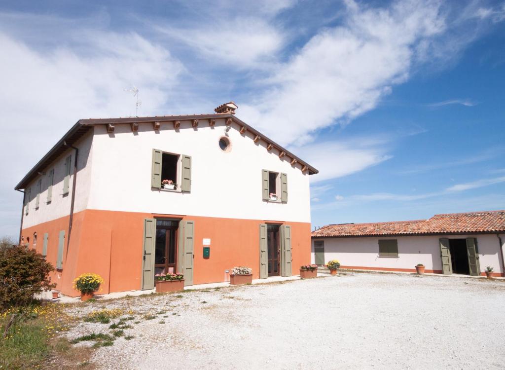 une grande maison blanche et orange avec une allée. dans l'établissement Cà Vincenzona, Wellness Area, à Faenza