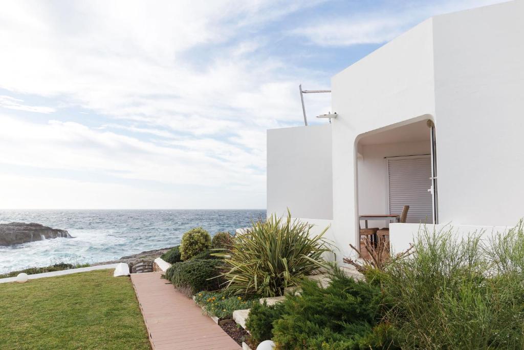 uma casa branca com vista para o oceano em BINIPARADISE - Villa Bini em Binibeca