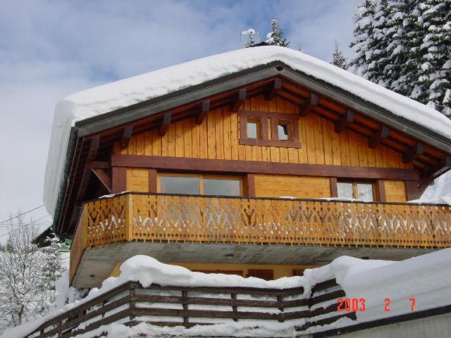 Domek z bali i balkonem w śniegu w obiekcie Chalet 2 Le Méridien Les Gets w mieście Les Gets