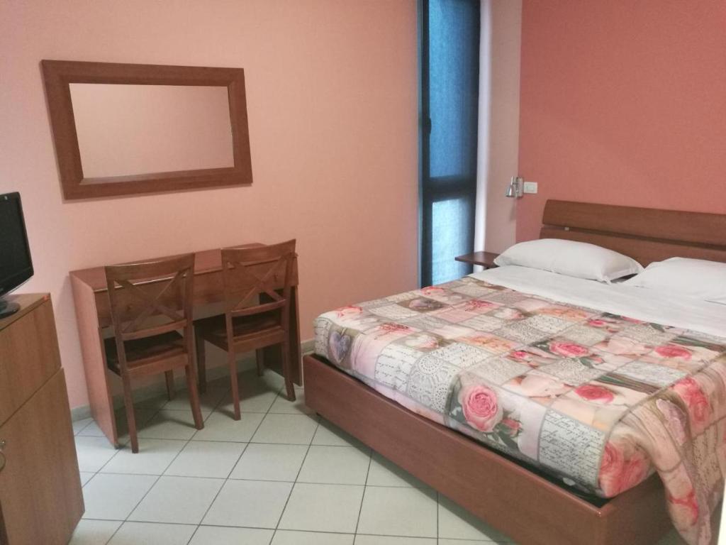 1 dormitorio con cama, mesa y escritorio en La Dea, en Pisa