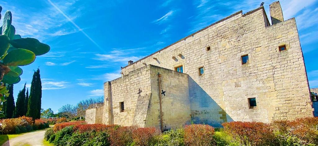 een groot stenen gebouw met een blauwe lucht op de achtergrond bij Masseria La Millenaria in San Foca