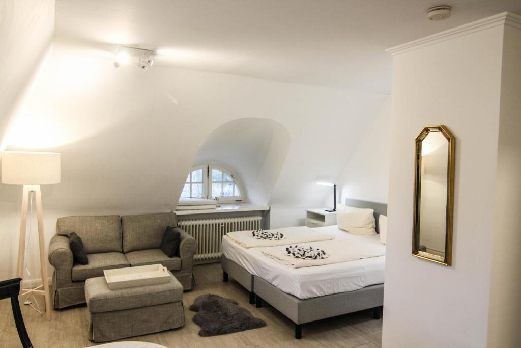 a bedroom with a bed and a chair and a mirror at Tina im Friesenhaus Sieben-Linden in Archsum