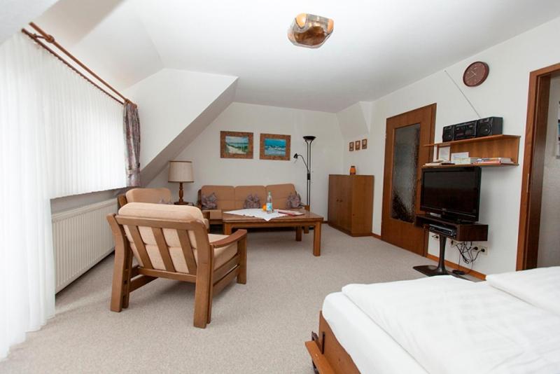 a bedroom with a bed and a table and a chair at Strandiris in Wenningstedt