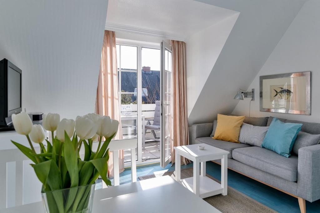 a living room with a couch and a table at Nelle 1 Stock in Wenningstedt