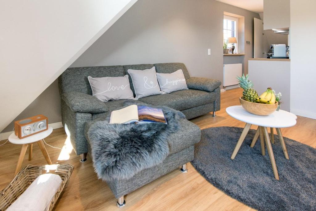 a living room with a couch and two tables at Sylt Liebe in Wenningstedt