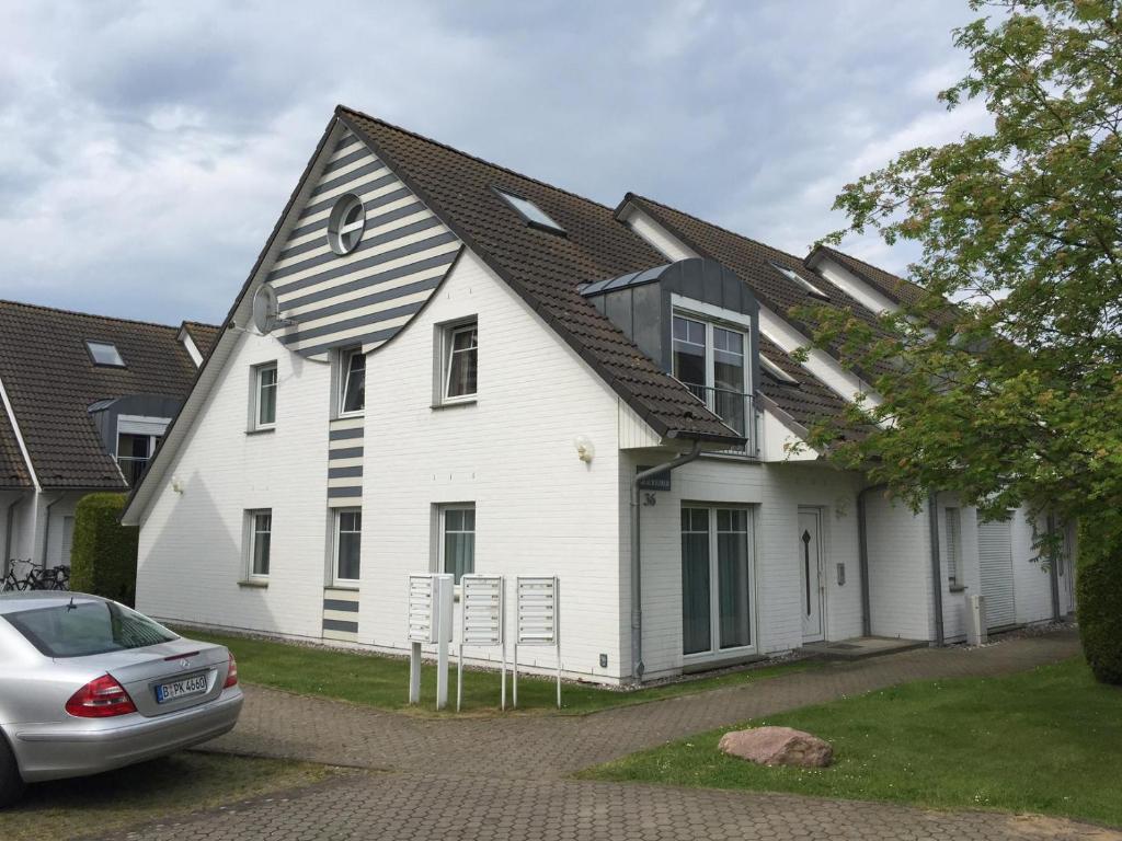 ein weißes Haus mit einem Gameradach in der Unterkunft Darsser Weg in Zingst