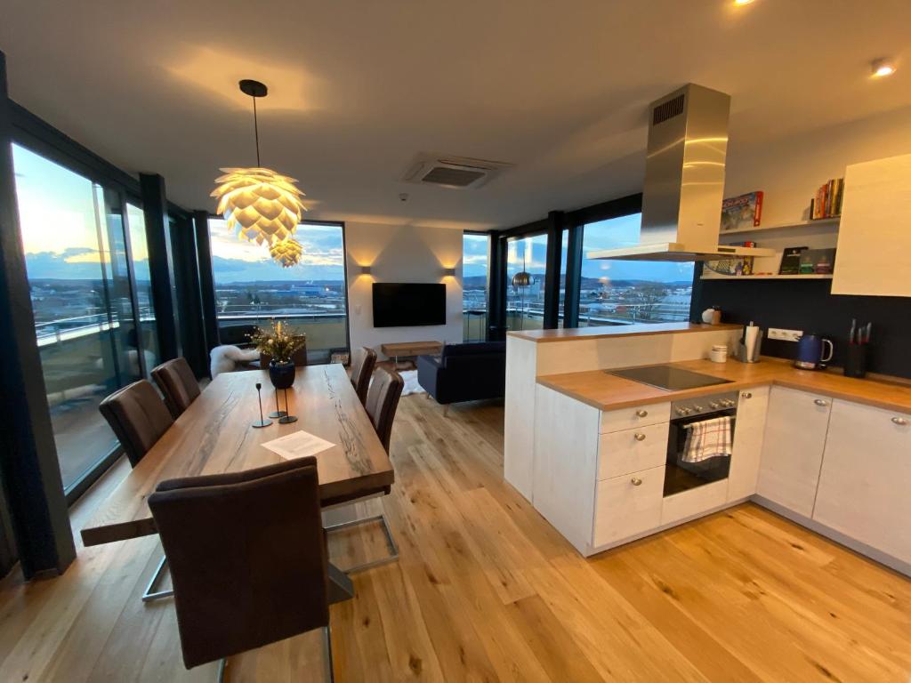 uma cozinha e sala de estar com mesa e cadeiras em ERBA Insel 140qm Penthouse em Bamberg