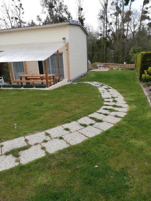 une passerelle dans une cour à côté d'une maison dans l'établissement Au cœur du jardin, à La Boussac