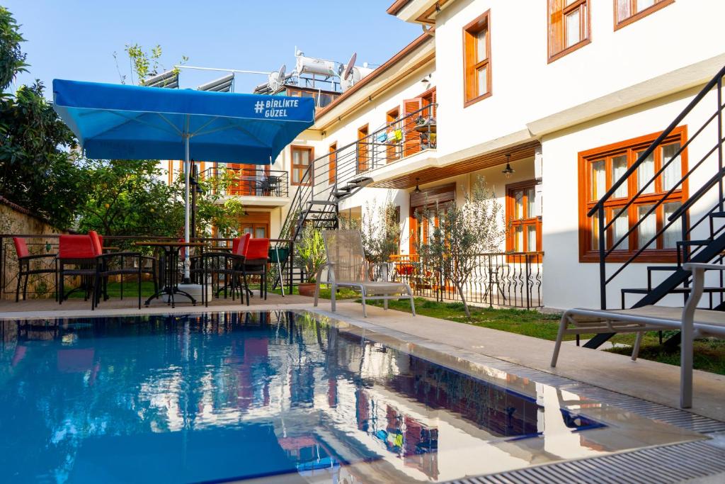 a swimming pool with an umbrella next to a building at Kaleici Aparts Antalya in Antalya