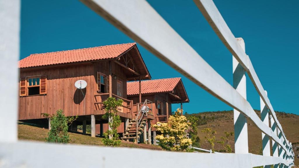 een groot houten huis met een rood dak bij Paraíso Dos Cânions in Bom Jardim da Serra