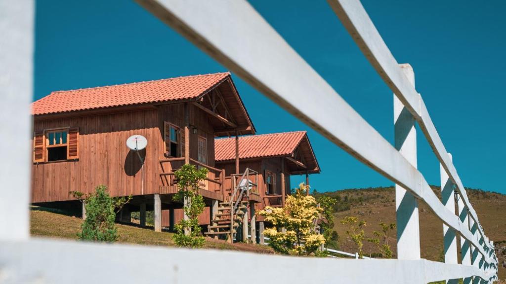 a large wooden house with a red roof at Paraíso Dos Cânions in Bom Jardim da Serra