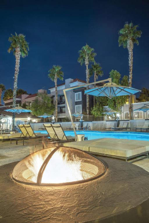 einen Brunnen in einem Pool in der Nacht mit Palmen in der Unterkunft Desert Rose Resort in Las Vegas