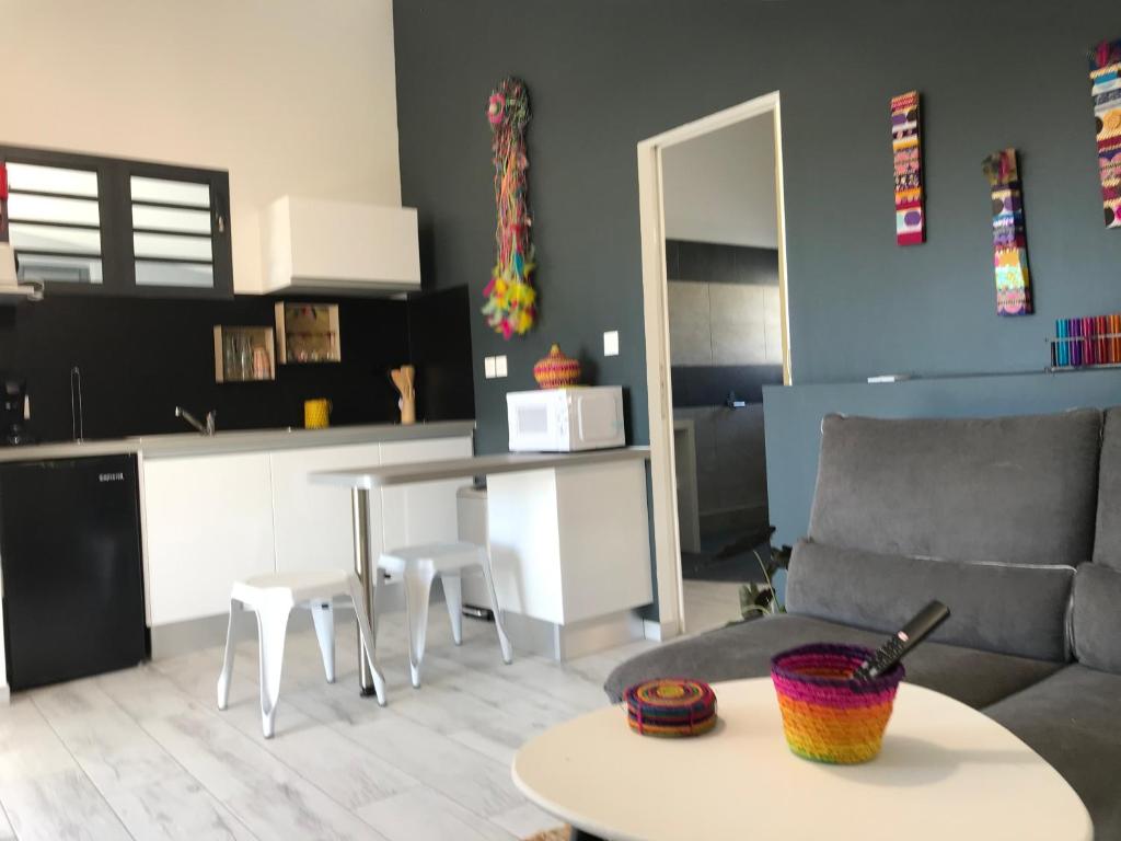ein Wohnzimmer mit einem Sofa und einem Tisch in der Unterkunft Piña Colada à Manapany les bains in Manapany-les Bains