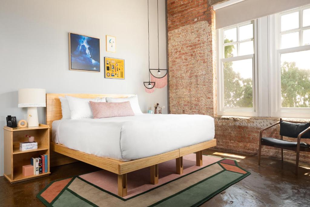 um quarto com uma cama e uma parede de tijolos em Canvas Hotel Dallas em Dallas