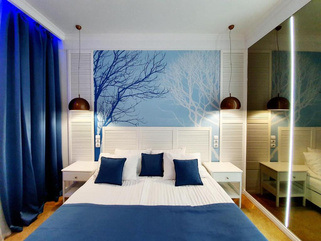 a bedroom with a large bed with blue pillows at Hotel Sluch in Starokostyantyniv