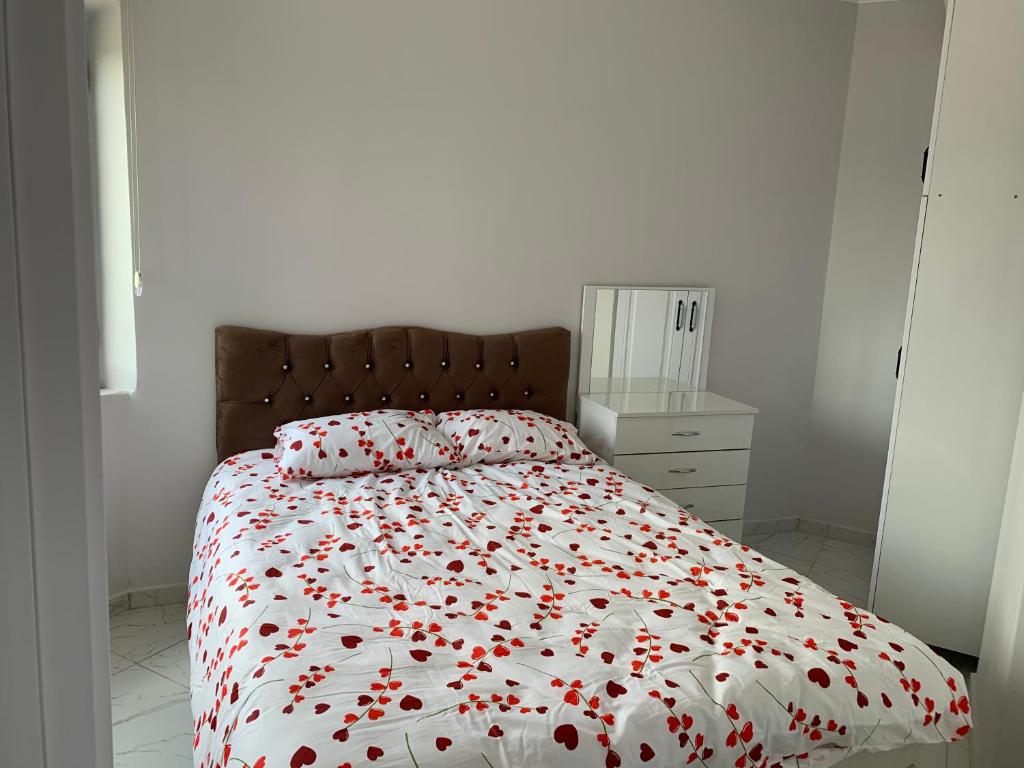 een slaapkamer met een bed met rode bloemen erop bij Kılıç apart otel in Dargeçit