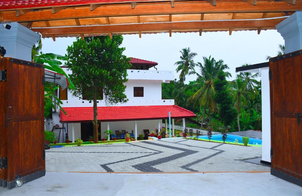 a building with a red roof and a swimming pool at Villa Talpe in Talpe