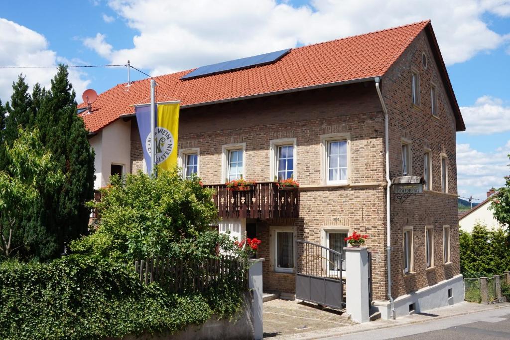 ein Backsteinhaus mit rotem Dach in der Unterkunft Gästehaus zum Goldberg in Dorsheim