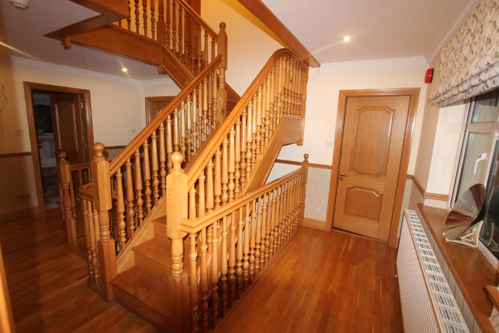 una escalera de caracol de madera en una casa con suelo de madera en Woodlands Guest Accomadation, en Oughterard