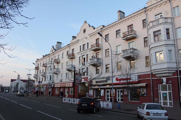 a city street with cars parked in front of buildings at Stylish apartment in the historic center in Chernihiv