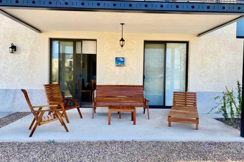 three wooden benches sitting on a patio in front of a building at Fantástico departamento en San Miguel de Allende in San Miguel de Allende