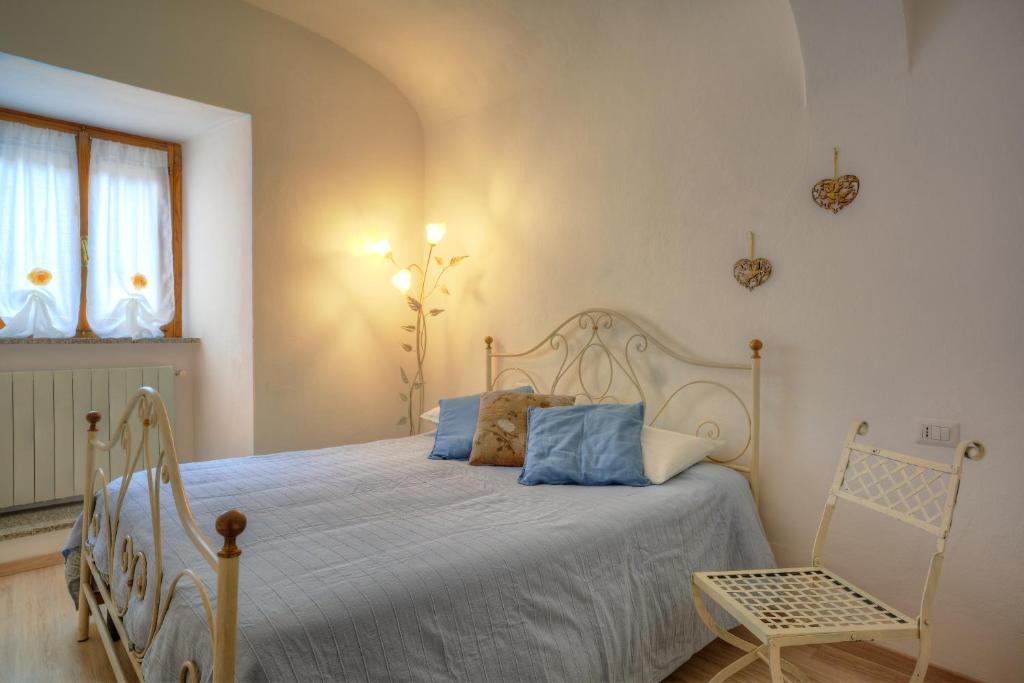 1 dormitorio con cama blanca y almohadas azules en Appartamento la Fortezza en Volterra