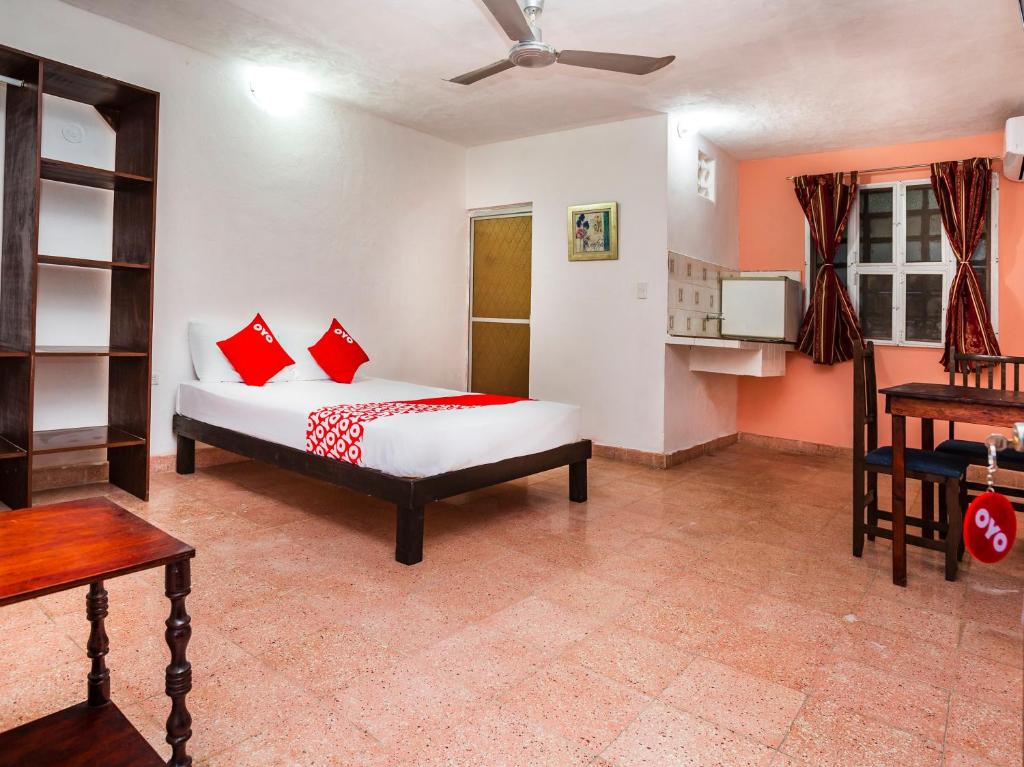 1 dormitorio con 1 cama con almohadas rojas en Casa Cuevas & Amaro en Mérida